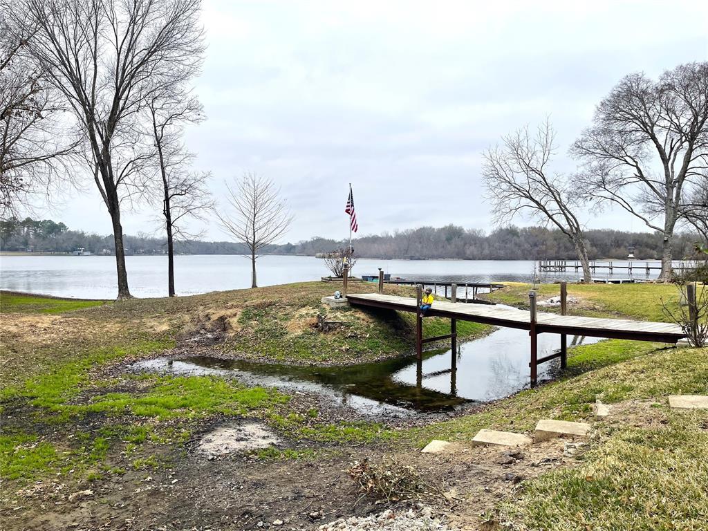 351 Club Lake Road Teague, TX 75860 - Photo 34 of 34 a view of a lake with a bench and trees around