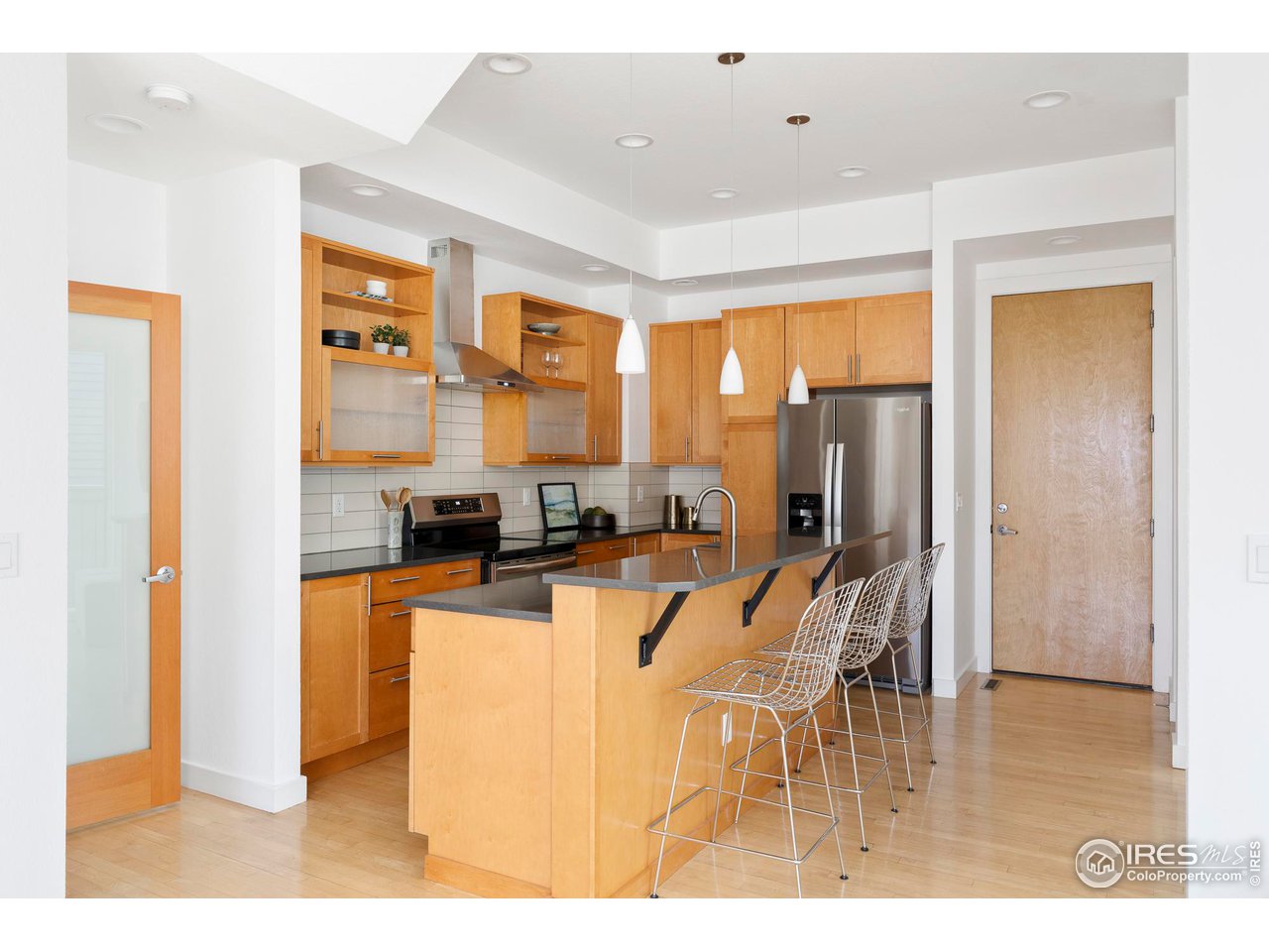 5247 5th Street Boulder, CO 80304 - Photo 6 of 34 a kitchen with stainless steel appliances kitchen island granite countertop a refrigerator a stove a oven with white cabinets