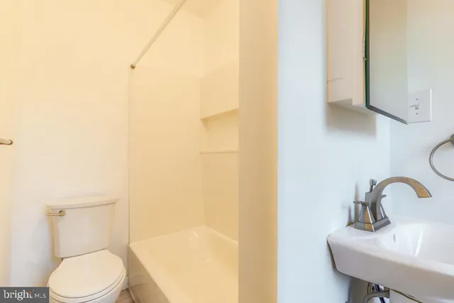 a white toilet sitting next to a bathroom sink