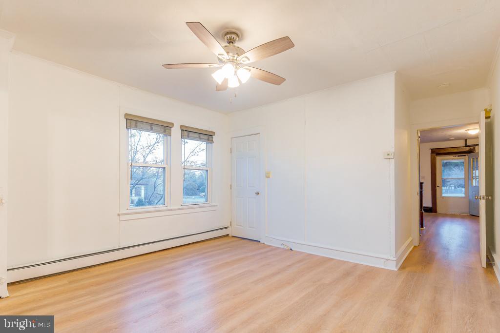 148 East Holly Avenue Pitman, NJ 08071 - Photo 7 of 11 an empty room with wooden floor chandelier fan and windows