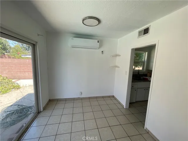 an empty room with wooden floor ceiling fan and windows