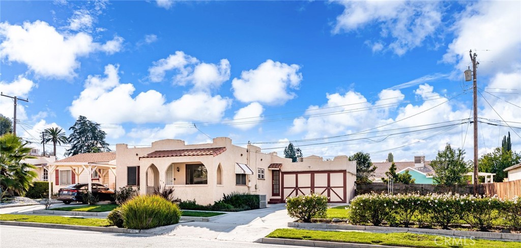 616 Monterey Street Redlands, CA 92373 - Photo 1 of 20 a view of a white house with a big yard and potted plants