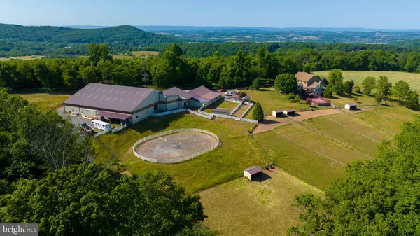 an aerial view of a house with pool and trees