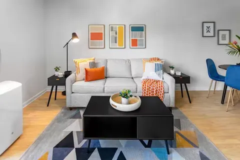 a living room with furniture and a dining table with chair