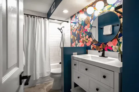 a bathroom with a sink vanity mirror and toilet