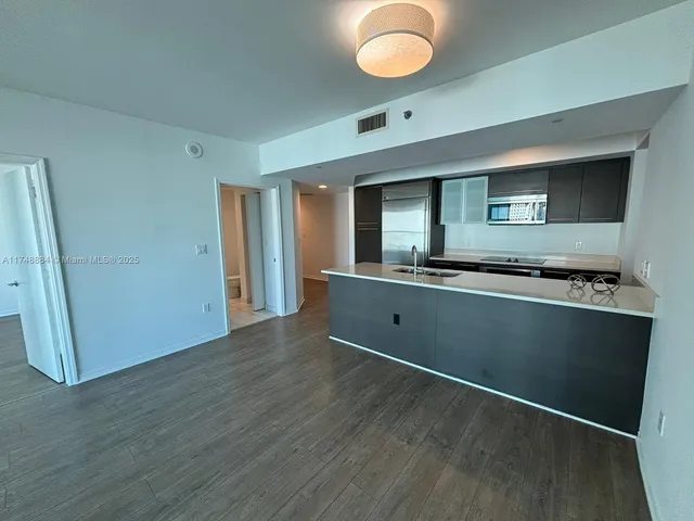 a view of kitchen with cabinets and wooden floor