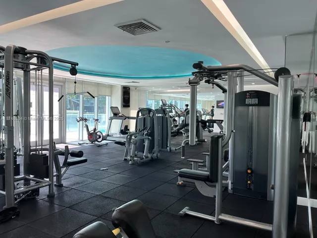 a view of a room with gym equipment and floor to ceiling window