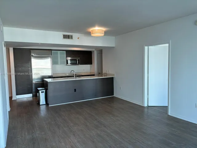 a view of kitchen with stainless steel appliances granite countertop a sink and a microwave