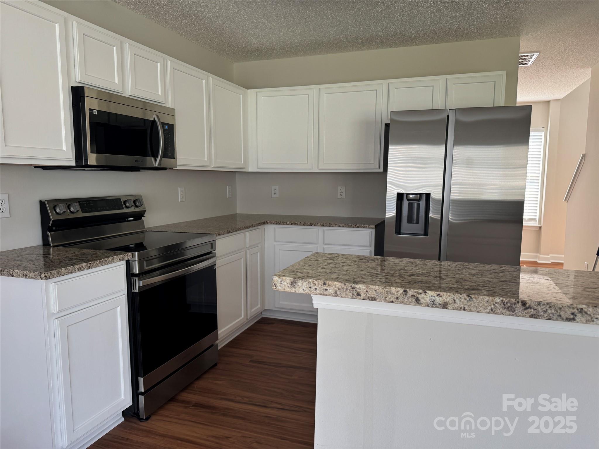 5506 Rogers Road Indian Trail, NC 28079 - Photo 13 of 30 a kitchen with stainless steel appliances granite countertop a sink stove and microwave