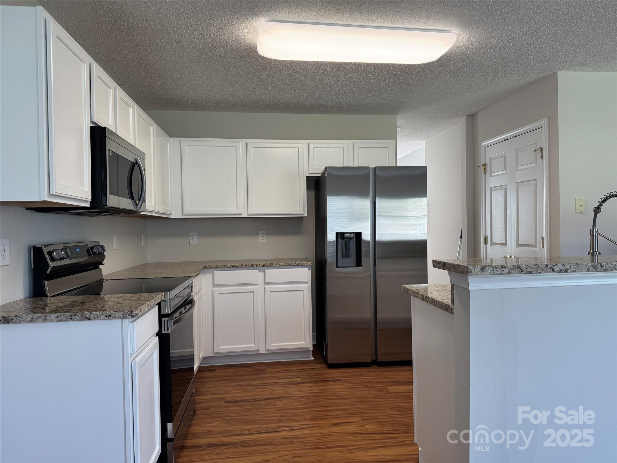 5506 Rogers Road Indian Trail, NC 28079 - Photo 14 of 30 a kitchen with stainless steel appliances granite countertop a refrigerator and a stove top oven