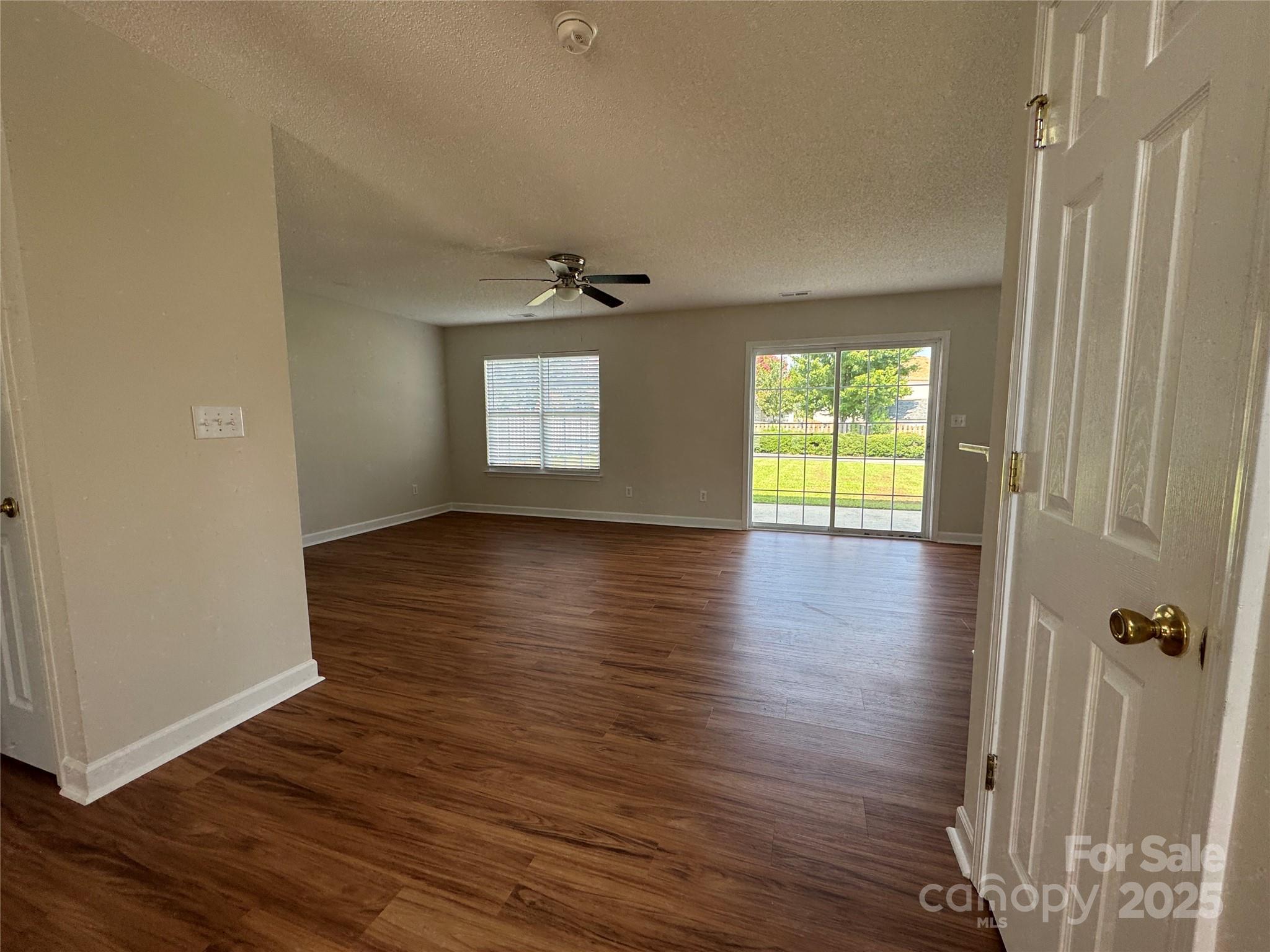 5506 Rogers Road Indian Trail, NC 28079 - Photo 6 of 30 an empty room with wooden floor and windows