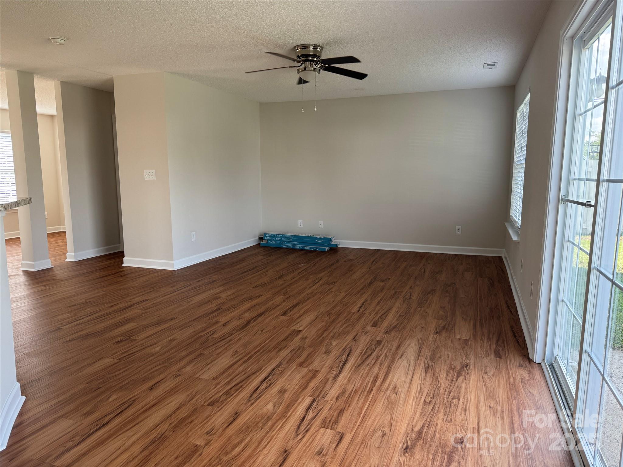 5506 Rogers Road Indian Trail, NC 28079 - Photo 8 of 30 an empty room with wooden floor and windows
