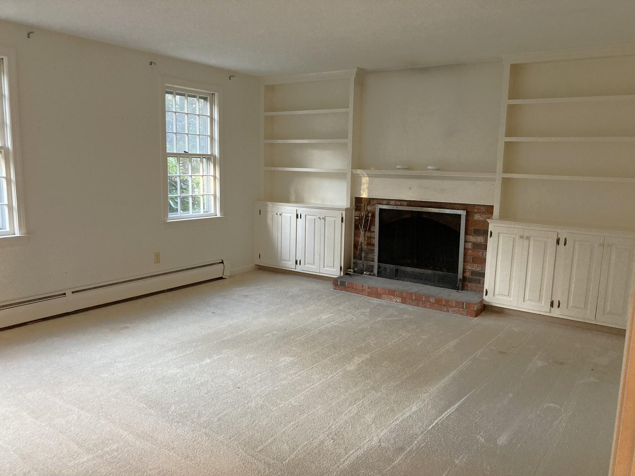426 Nottingham Drive Centerville, MA 02632 - Photo 6 of 25 an empty room with a fireplace and window