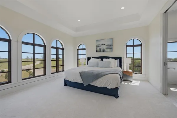 a spacious bedroom with a bed and a chandelier