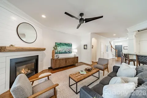 a living room with furniture a fireplace a rug and a window