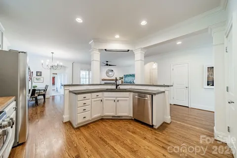 a kitchen with granite countertop white cabinets and stainless steel appliances