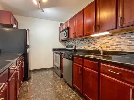 a kitchen with stainless steel appliances granite countertop wooden cabinets a sink and dishwasher