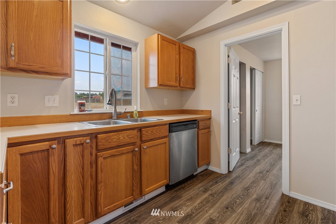 18126 Leitner Road Southwest Rochester, WA 98579 - Photo 12 of 29 a kitchen with stainless steel appliances granite countertop a sink and cabinets with wooden floor