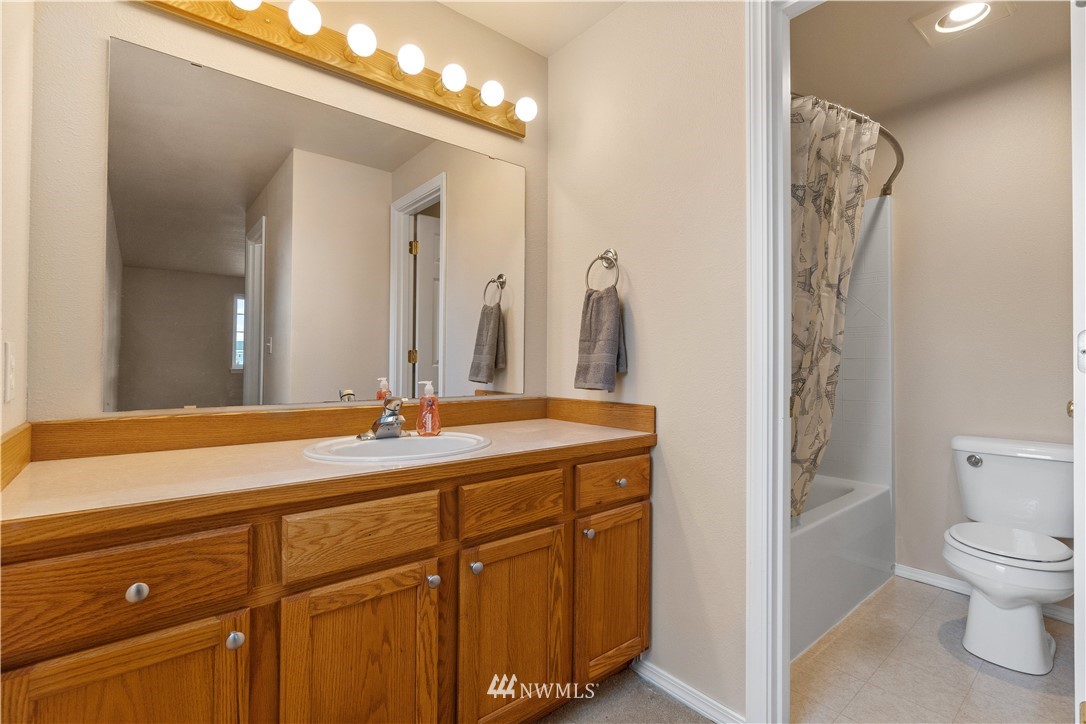 18126 Leitner Road Southwest Rochester, WA 98579 - Photo 22 of 29 a bathroom with a granite countertop sink a toilet and a mirror