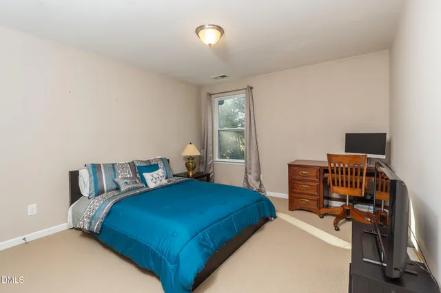 a bedroom with bed and wooden floor