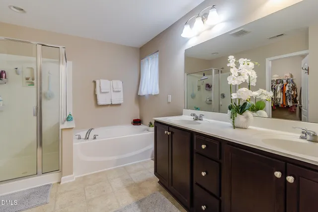 a spacious bathroom with a tub sink and a mirror