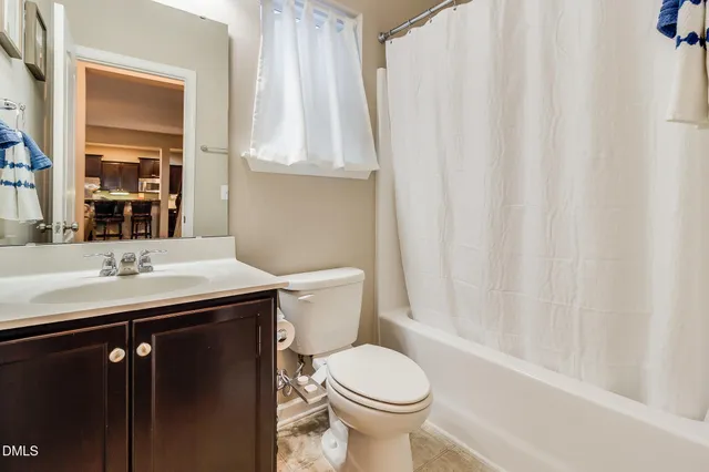 a bathroom with a sink a toilet and shower curtain