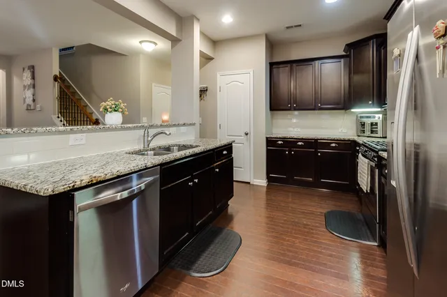 a kitchen with granite countertop stainless steel appliances and wooden cabinets