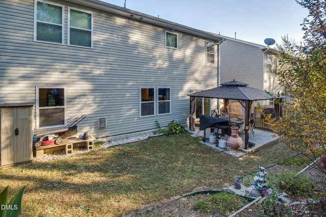 a view of a house with backyard and sitting area