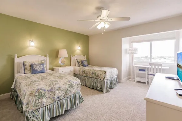 a bedroom with two beds and a large window