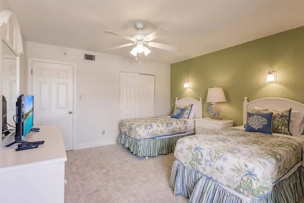 a spacious bedroom with two beds and a chandelier