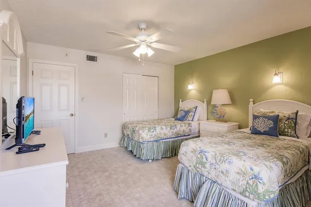 a spacious bedroom with two beds and a chandelier