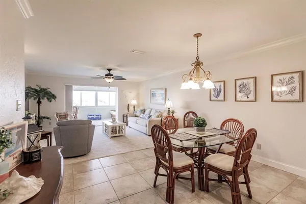 a dining room with furniture a chandelier and wooden floor