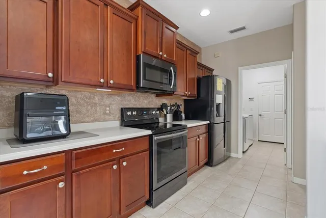 a kitchen with stainless steel appliances granite countertop a refrigerator a stove top oven a sink and dishwasher