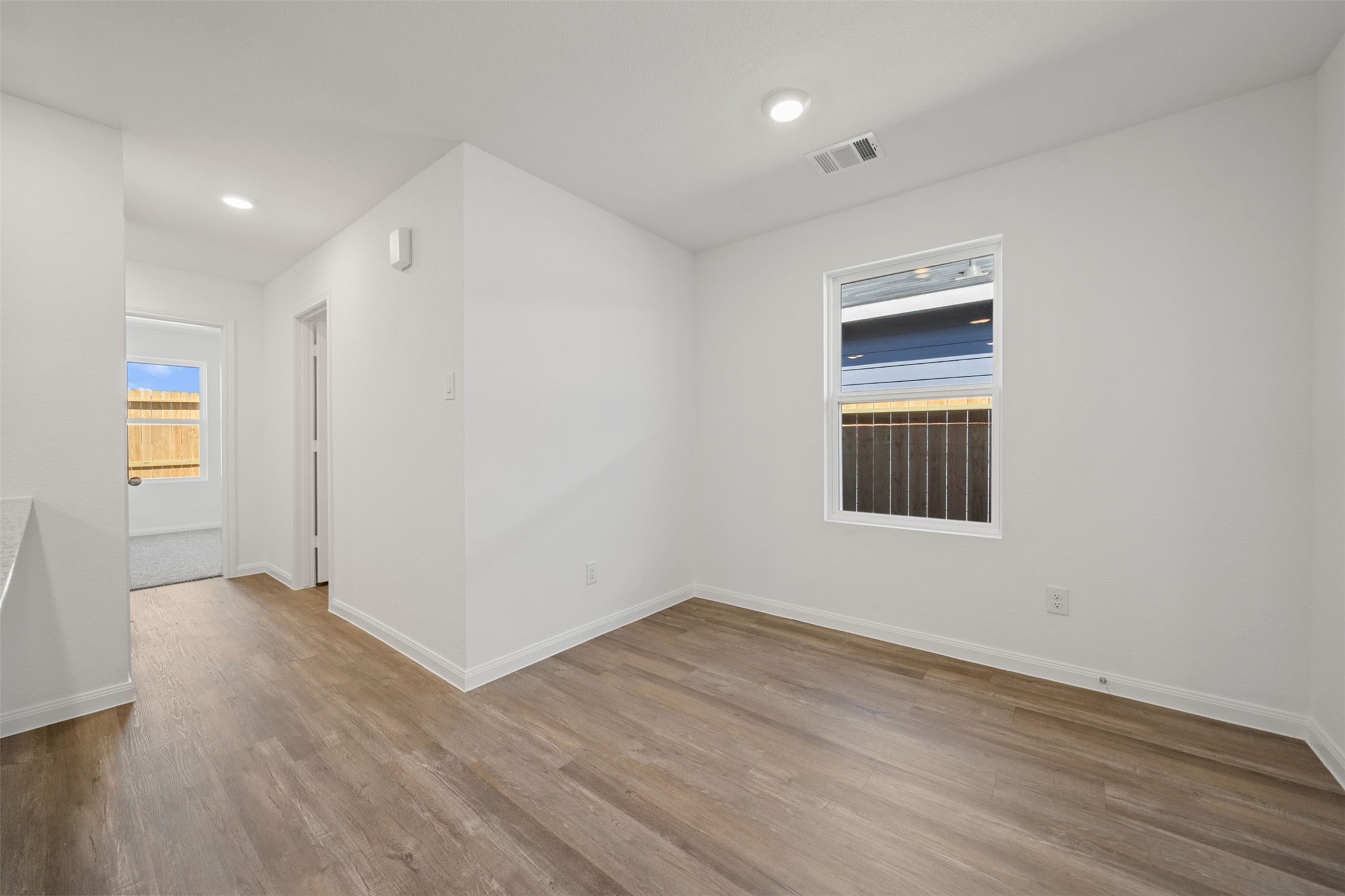 12327 Sword Point Court Willis, TX 77378 - Photo 14 of 30 a view of an empty room with wooden floor and a window