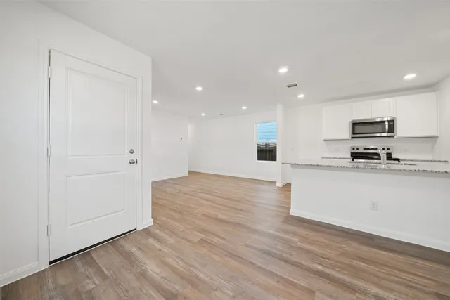a view of kitchen with wooden floor and electronic appliances