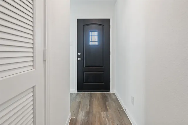 a view of a hallway with wooden floor