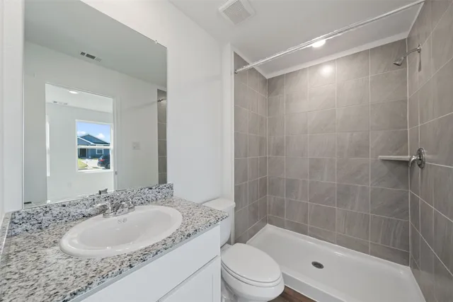 a bathroom with a granite countertop sink toilet and shower