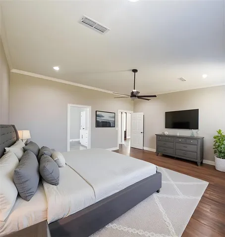 a bedroom with a bed a couch and a flat screen tv