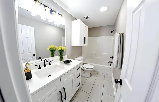 a bathroom with a sink a toilet and shower