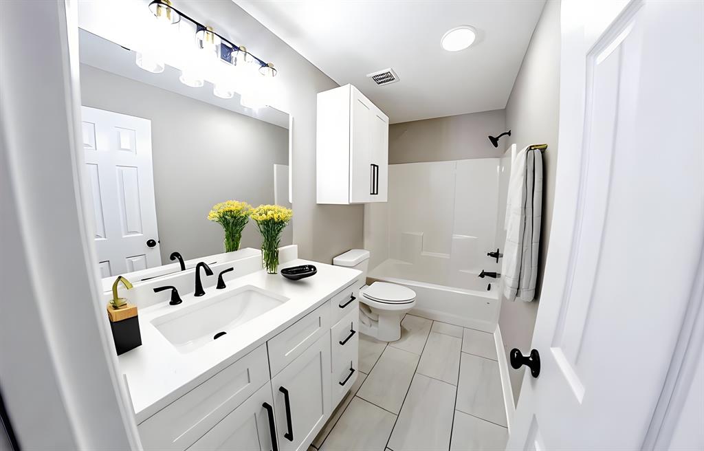 990 Baylor’s Way Reno, TX 75462 - Photo 15 of 22 a bathroom with a sink a toilet and shower