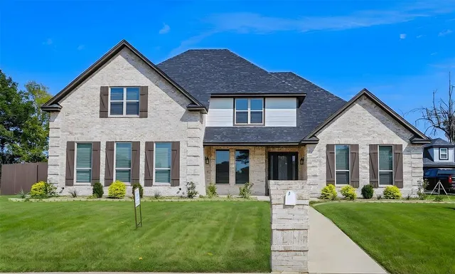 a front view of a house with yard and green space