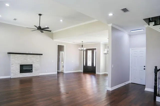 a view of empty room with wooden floor and fireplace