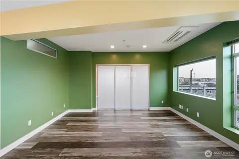 a view of a hallway with wooden floor and a bathroom