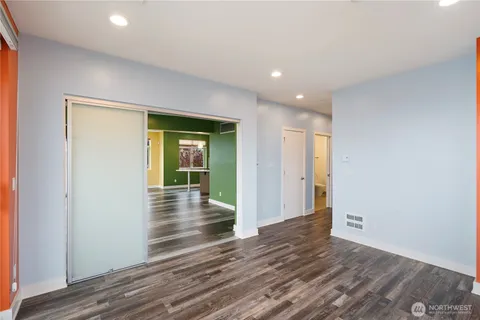 a view of empty room with wooden floor and fan