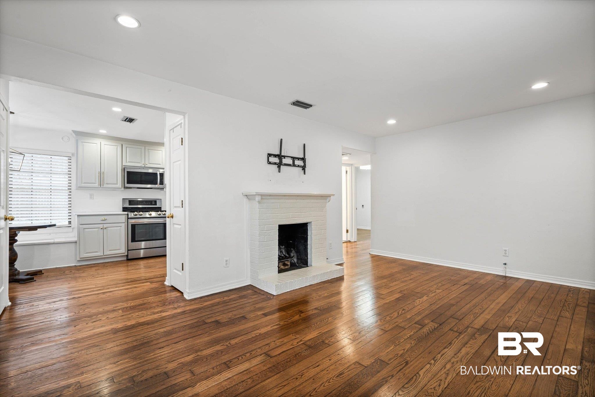 11 York Place Mobile, AL 36608 - Photo 4 of 24 Unfurnished living room with a brick fireplace, dark wood finished floors, and recessed lighting