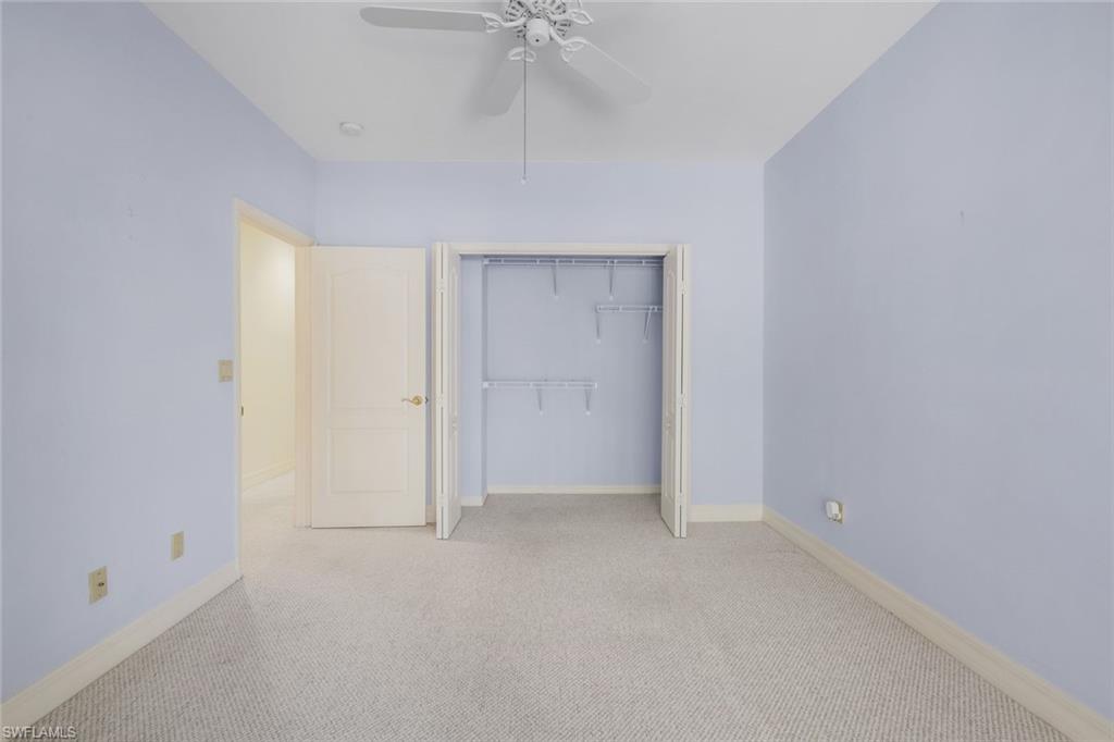 2451 Game Hawk Court, Unit 2502 Naples, FL 34105 - Photo 13 of 30 an empty room with a ceiling fan and carpet