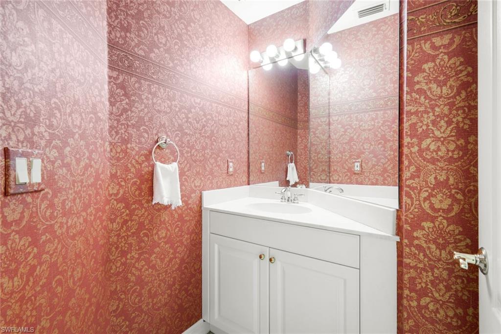 2451 Game Hawk Court, Unit 2502 Naples, FL 34105 - Photo 20 of 30 a bathroom with a sink vanity and a mirror