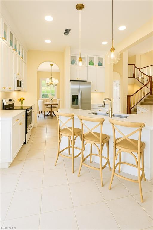 2451 Game Hawk Court, Unit 2502 Naples, FL 34105 - Photo 4 of 30 a kitchen with stainless steel appliances kitchen island granite countertop dining table chairs and a granite counter tops