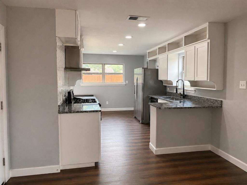 812 Irwin Drive Hurst, TX 76053 - Photo 7 of 16 Kitchen featuring white cabinetry, granite-style countertops, stainless steel appliances, a tile backsplash, and wood-finish flooring