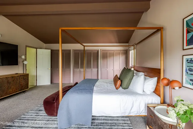 a bedroom with furniture and a flat screen tv